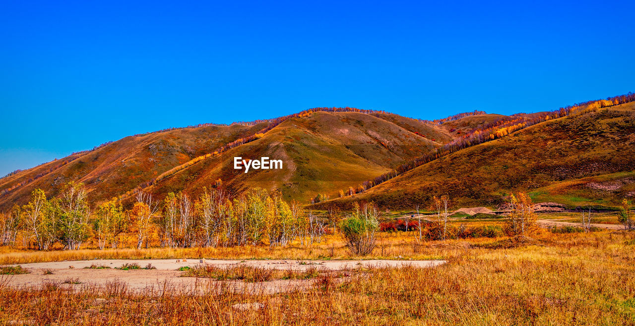 Scenic view of mountains against clear blue sky