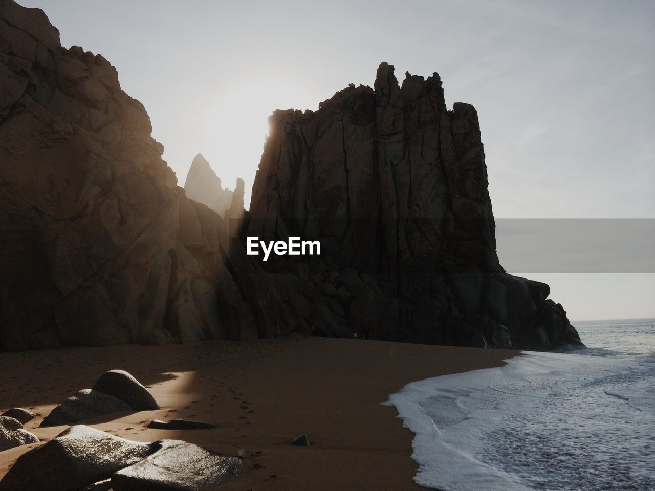 Rock formations on beach against clear sky