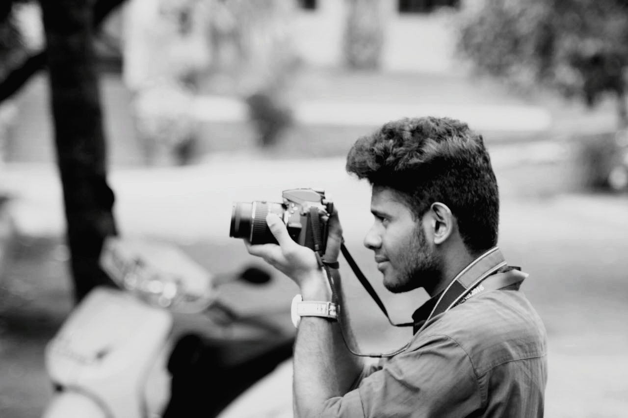 Man photographing through camera outdoors