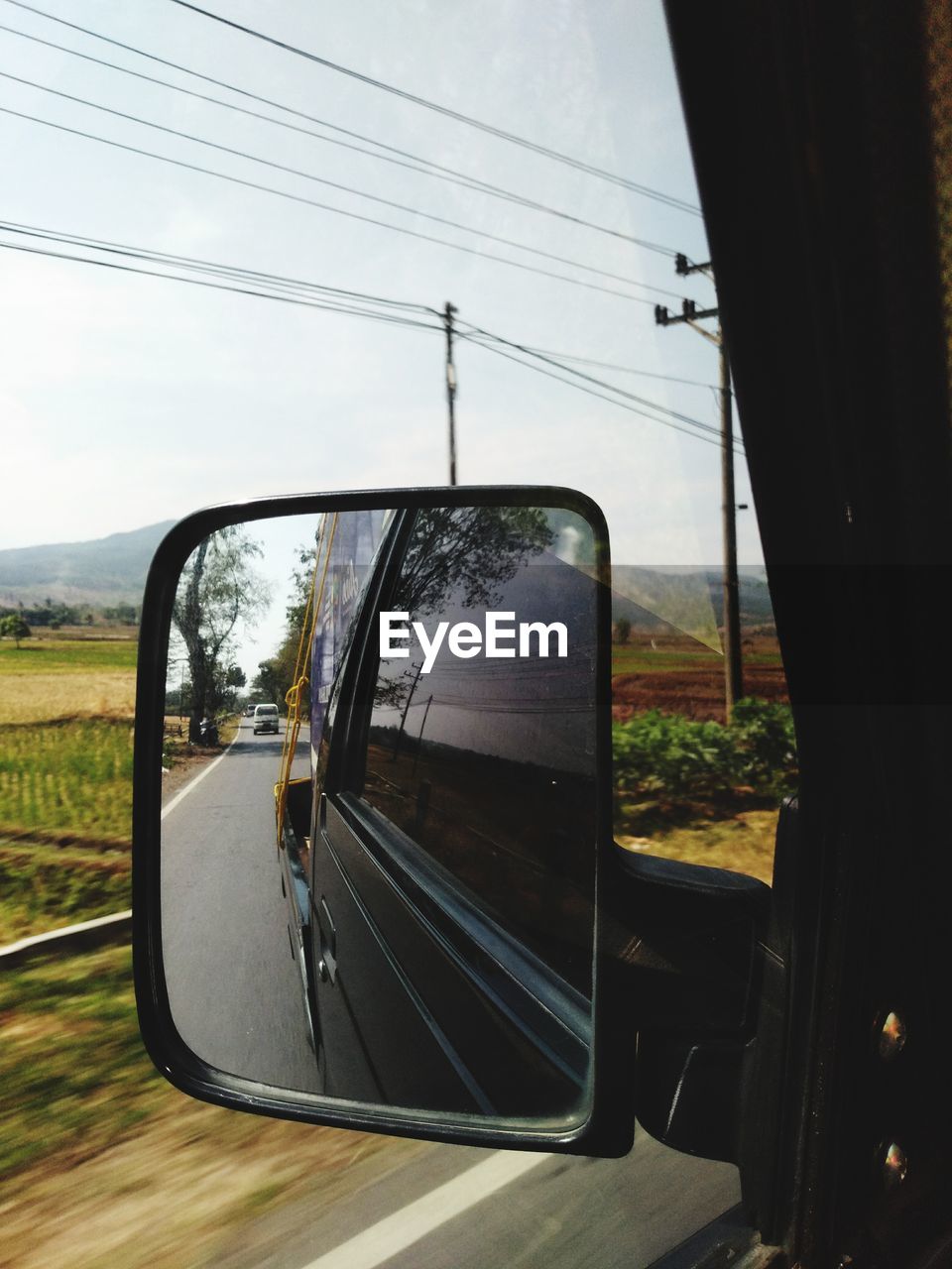 REFLECTION OF SIDE-VIEW MIRROR AGAINST CLEAR SKY