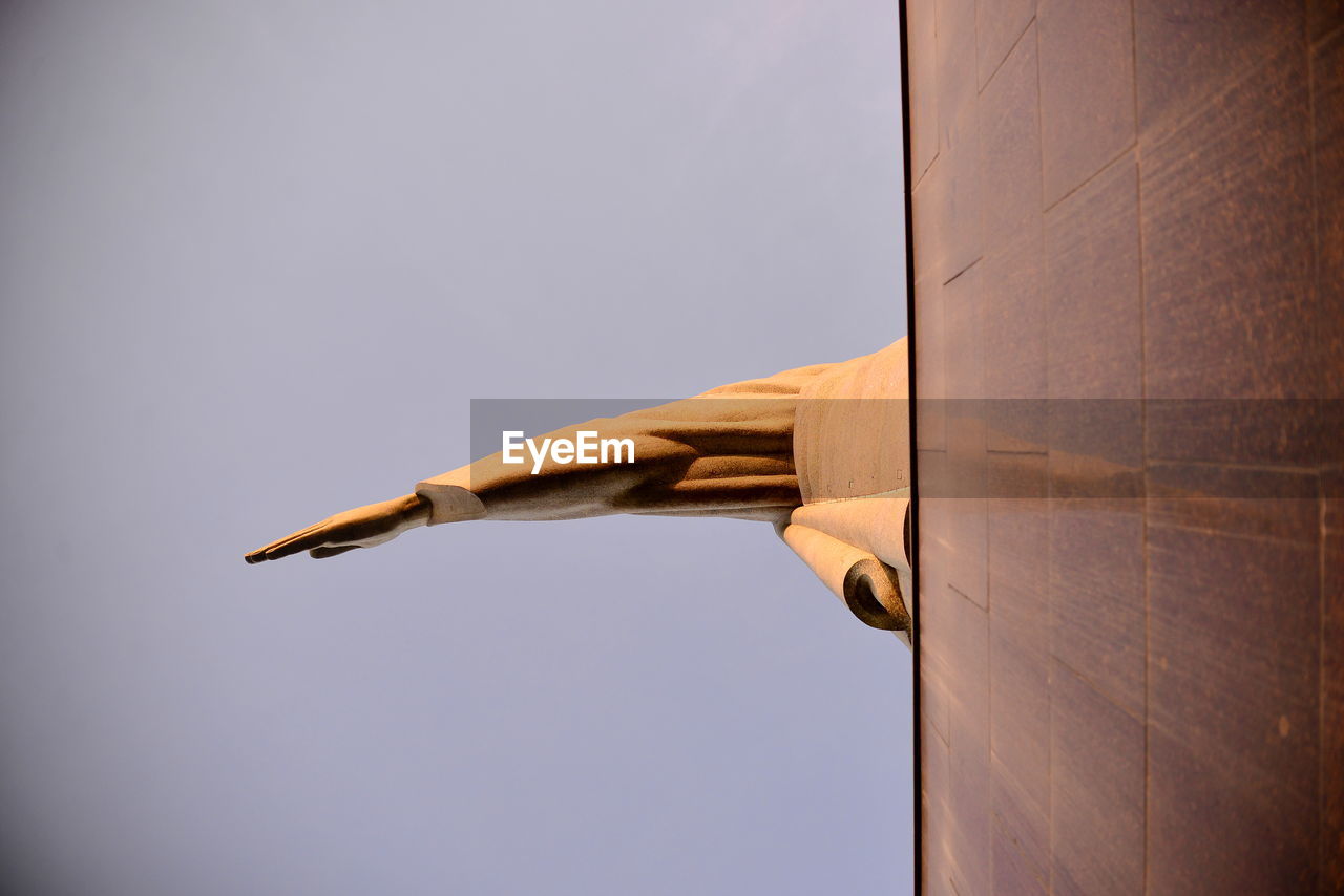 Low angle view of arm of christ the redeemer against clear sky