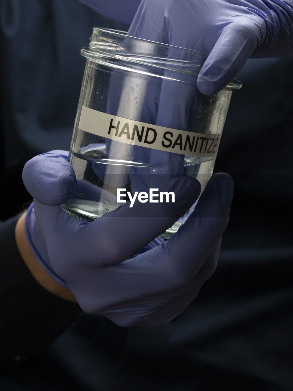 Midsection of person using hand sanitizer