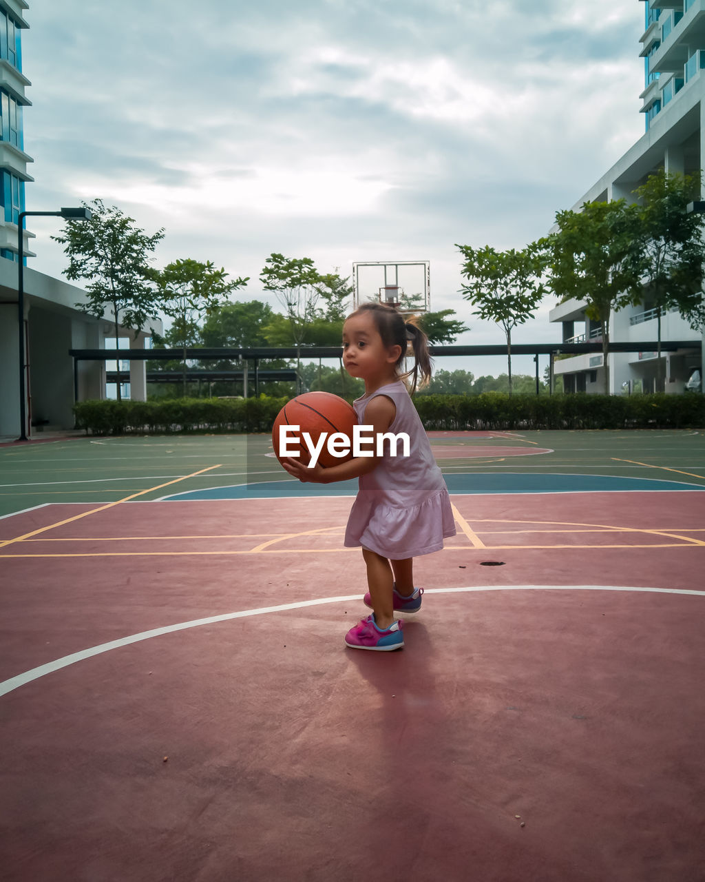 Full length of girl playing with basketball