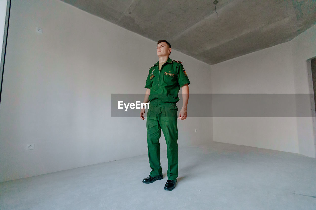Full length of soldier standing against wall