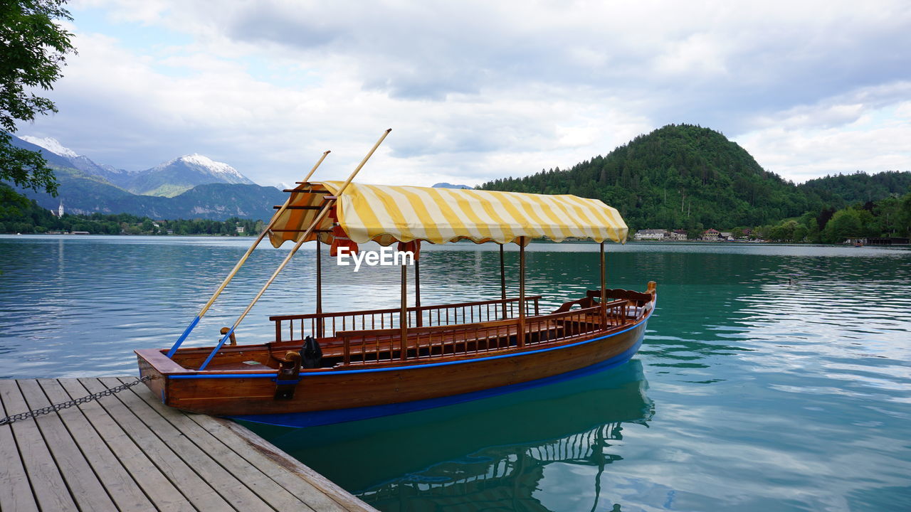 Ship moored at lake against sky