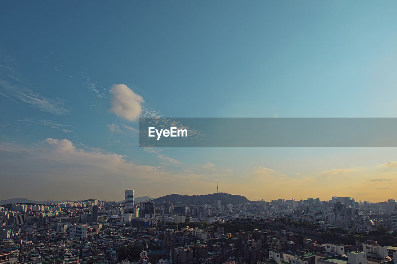 Aerial view of buildings in city against sky during sunset