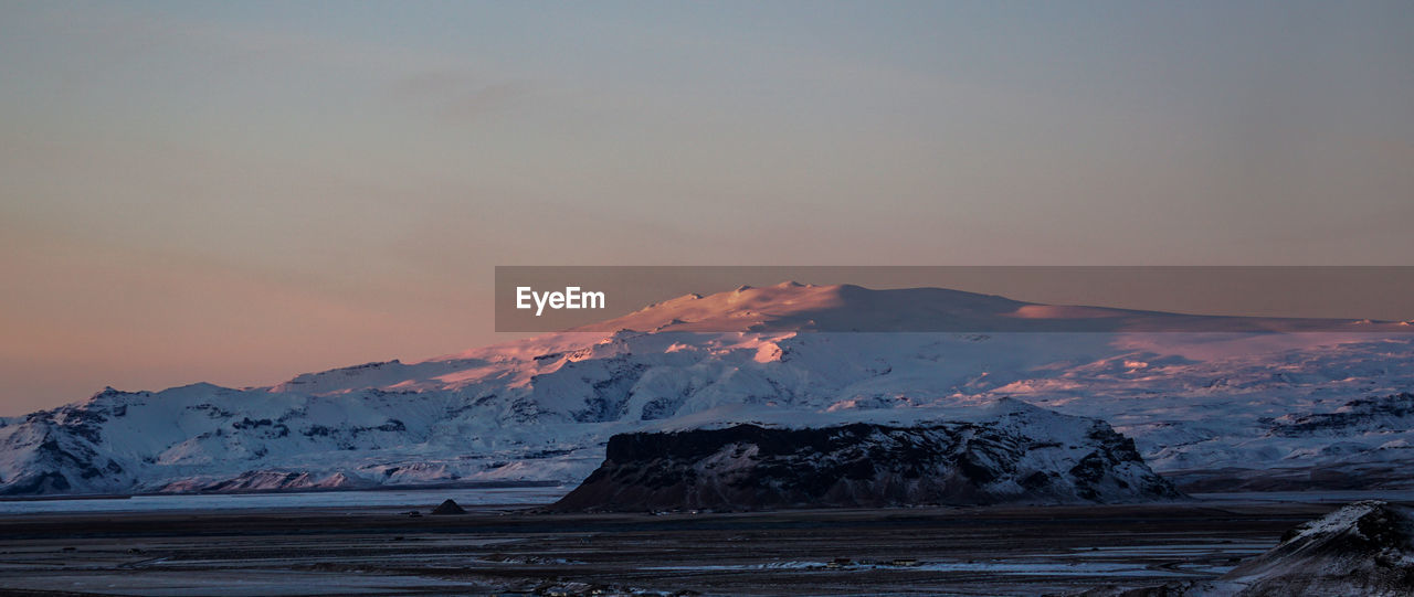 Scenic view of snowcapped mountains against sky during sunset