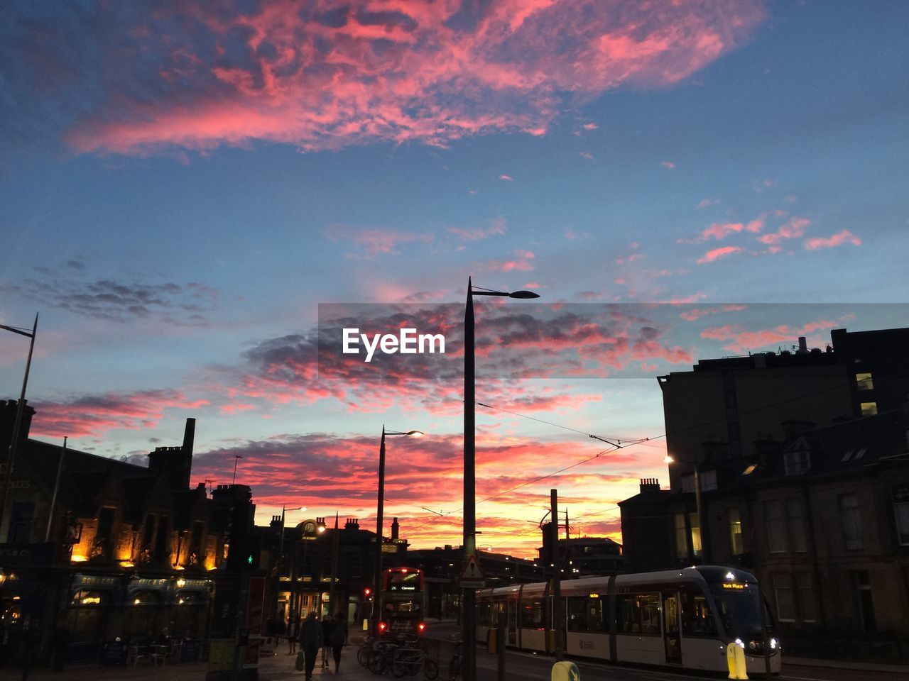 Cityscape against dramatic sky during sunset