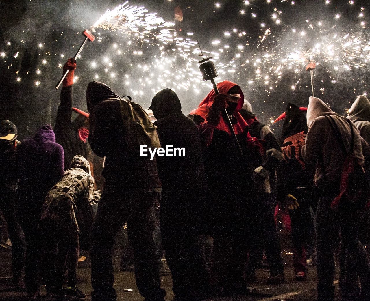 Crowd in hooded shirts enjoying rock music at concert