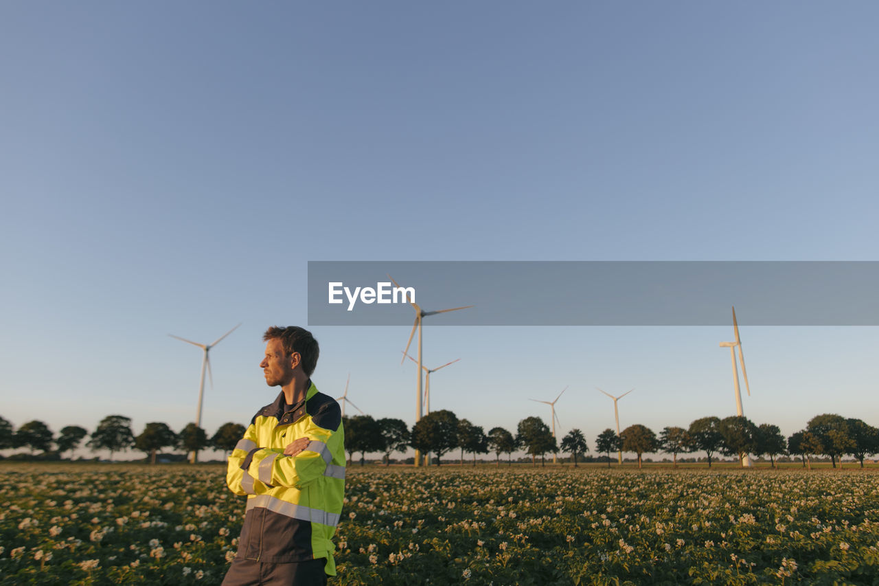 Engineer standing in a field at a wind farm