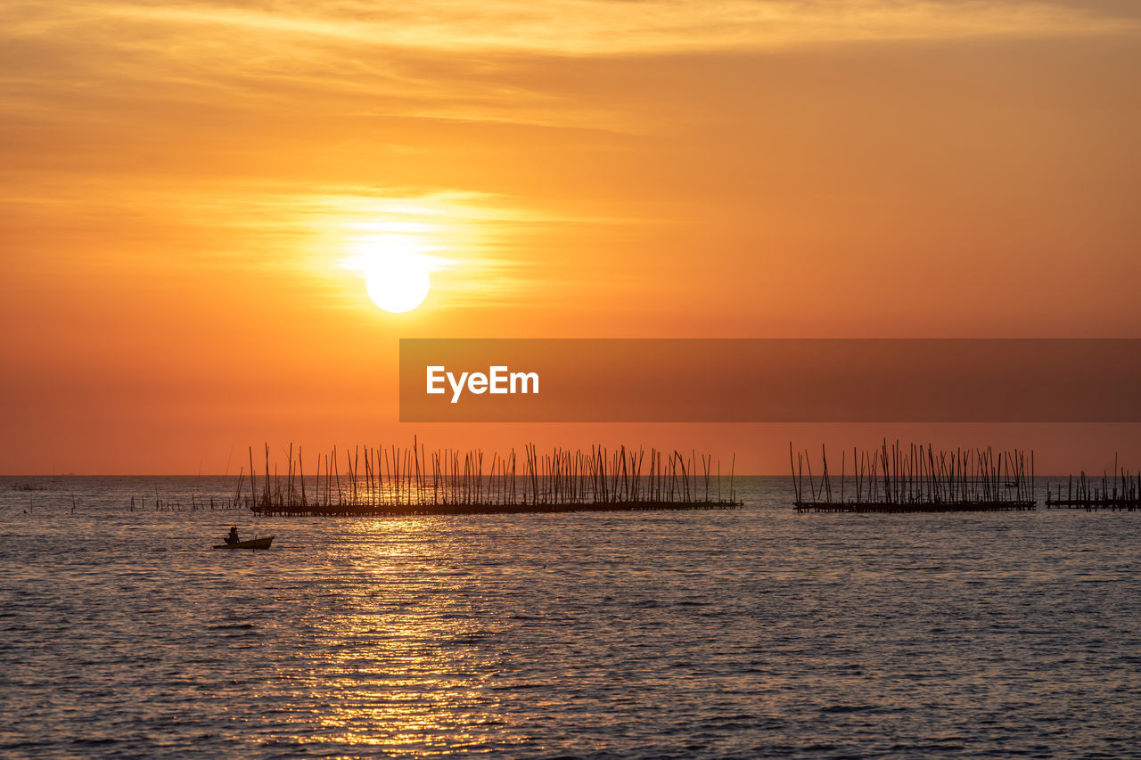 Oyster farm in the sea and beautiful sky sunset background , sun and cloud landscape nature thailand