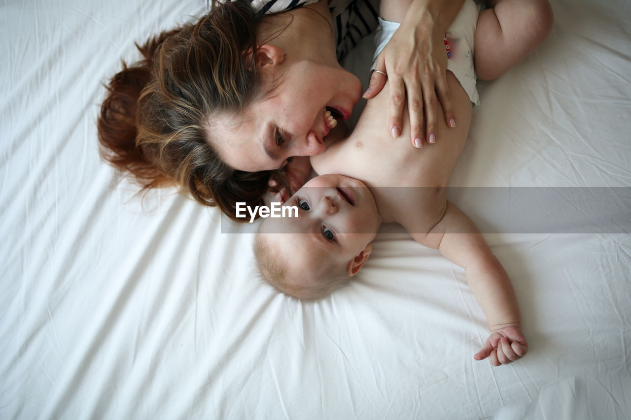 Mother gently hugs son, top view, white background. concept motherhood and emotions.