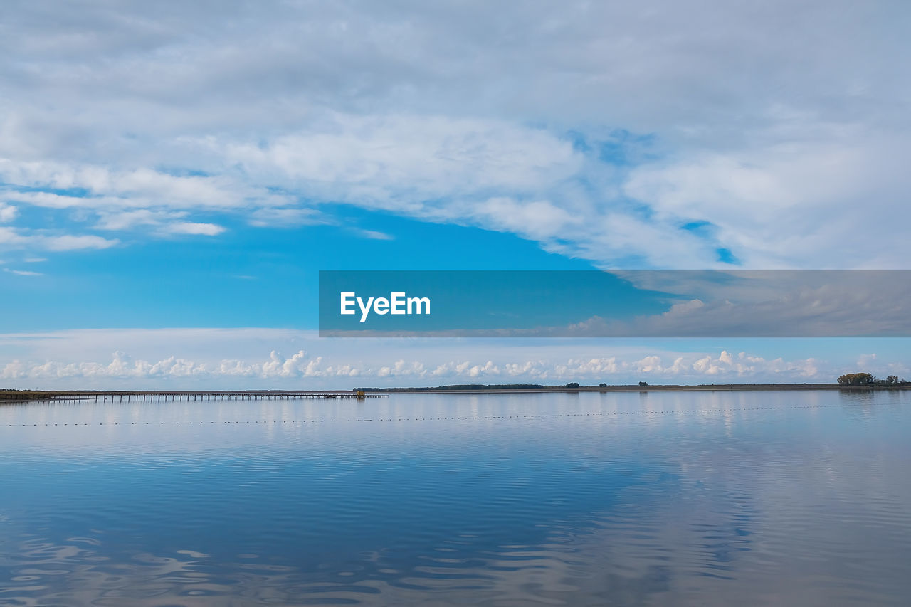 SCENIC VIEW OF LAKE AGAINST CLOUDY SKY