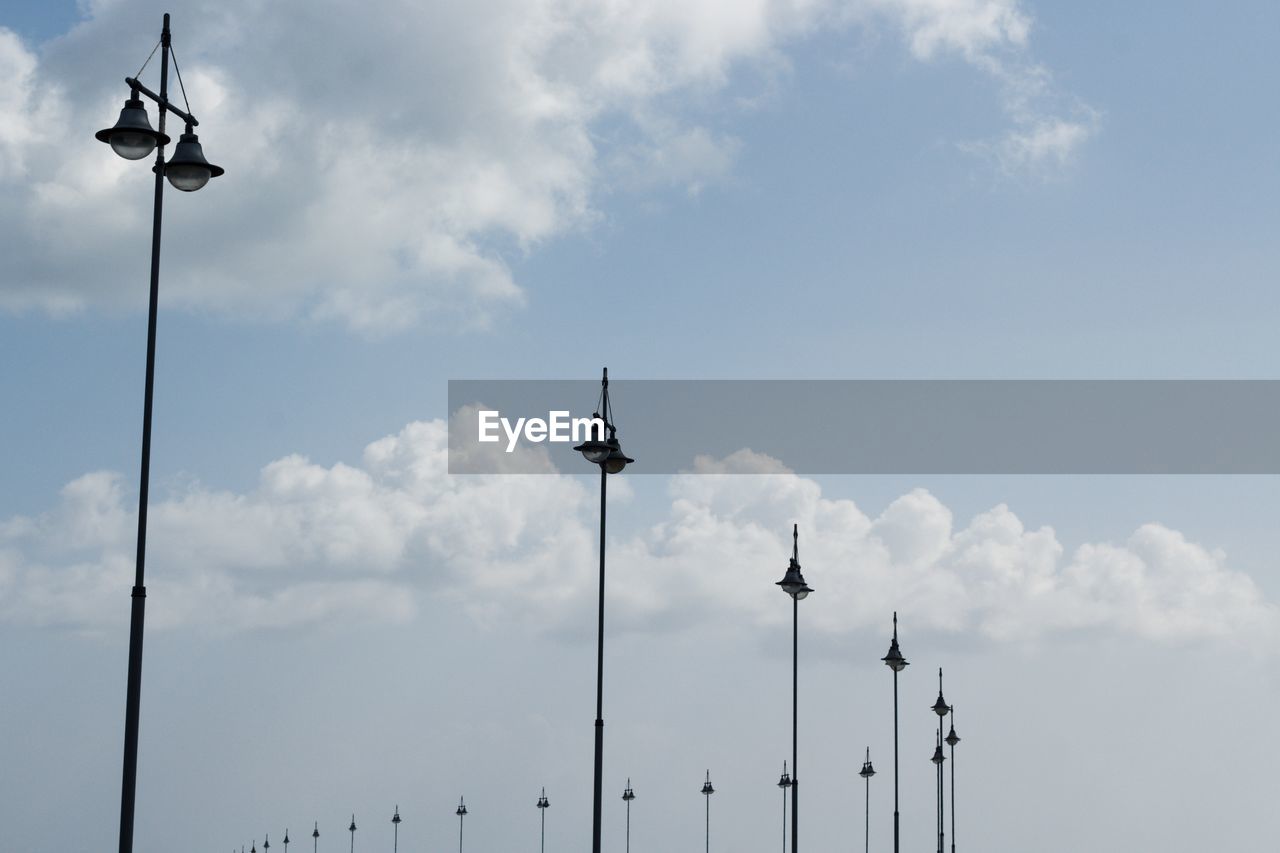 Low angle view of street light against cloudy sky