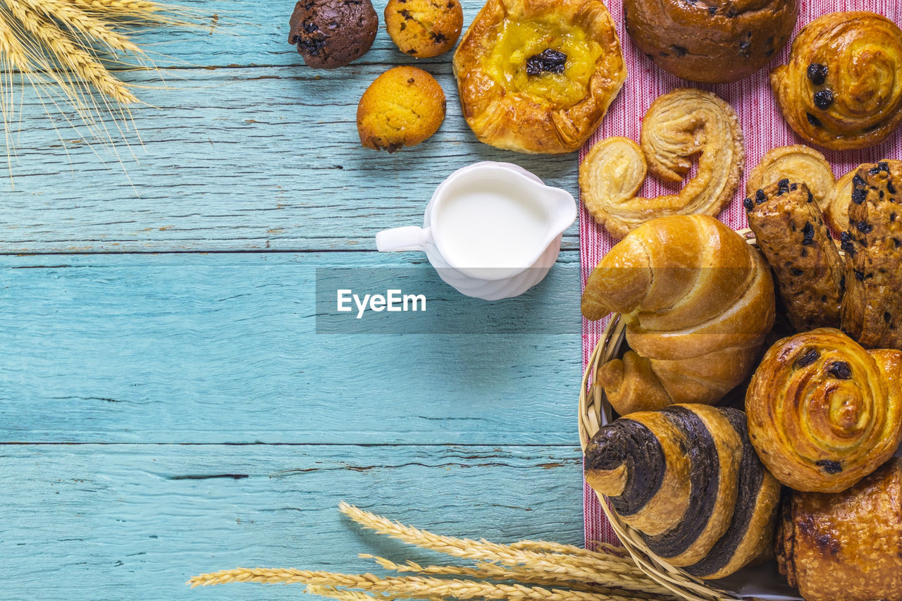 Close-up of croissants with pitcher on table