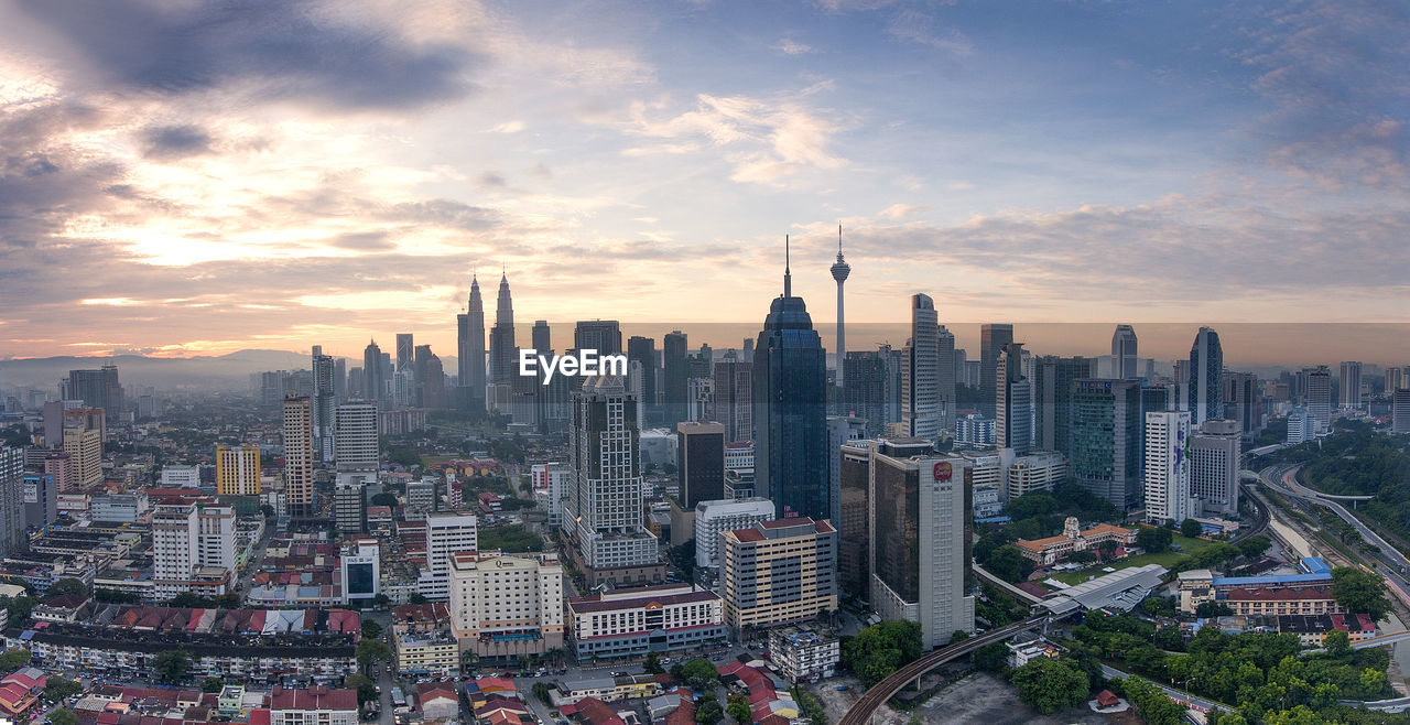 Aerial view of buildings in city against sky during sunset