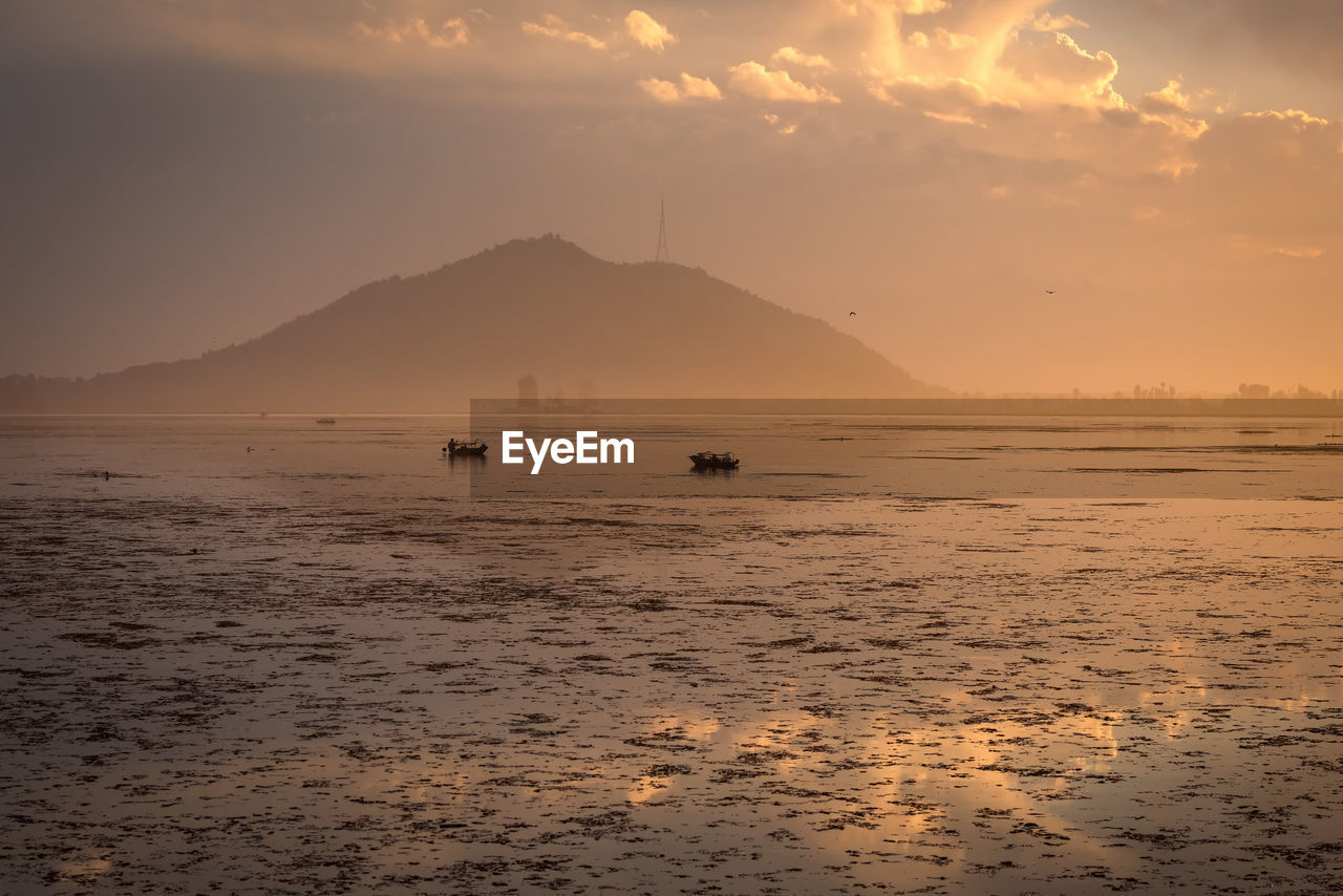 Scenic view of beach against sky during sunset