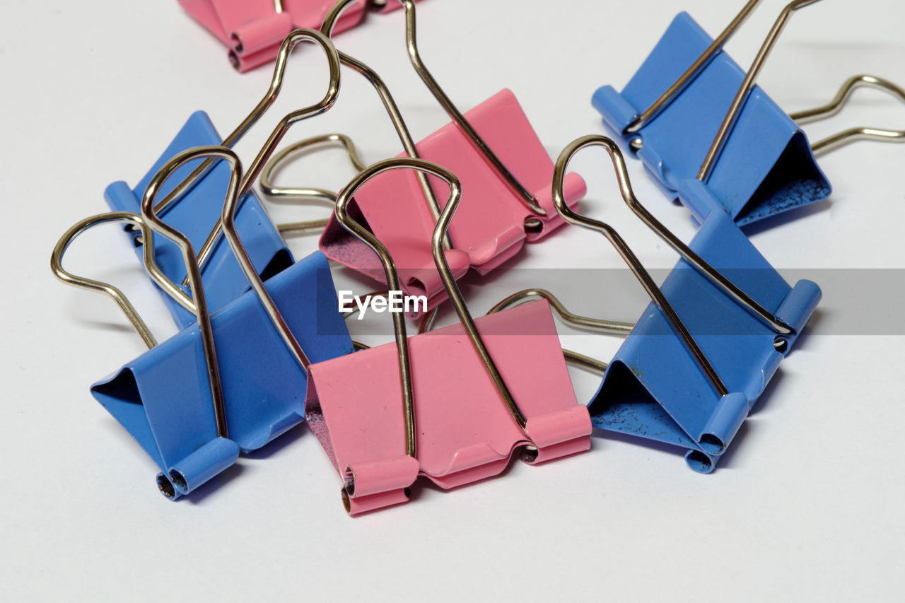 Close-up of paper clips over white background