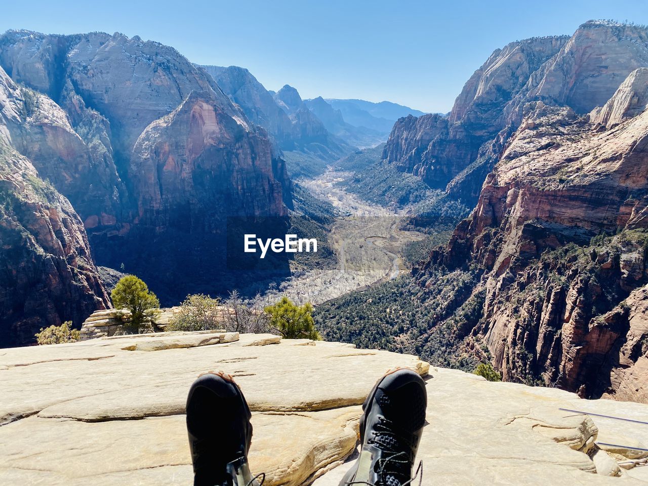 LOW SECTION OF PEOPLE ON ROCKS AGAINST MOUNTAIN RANGE