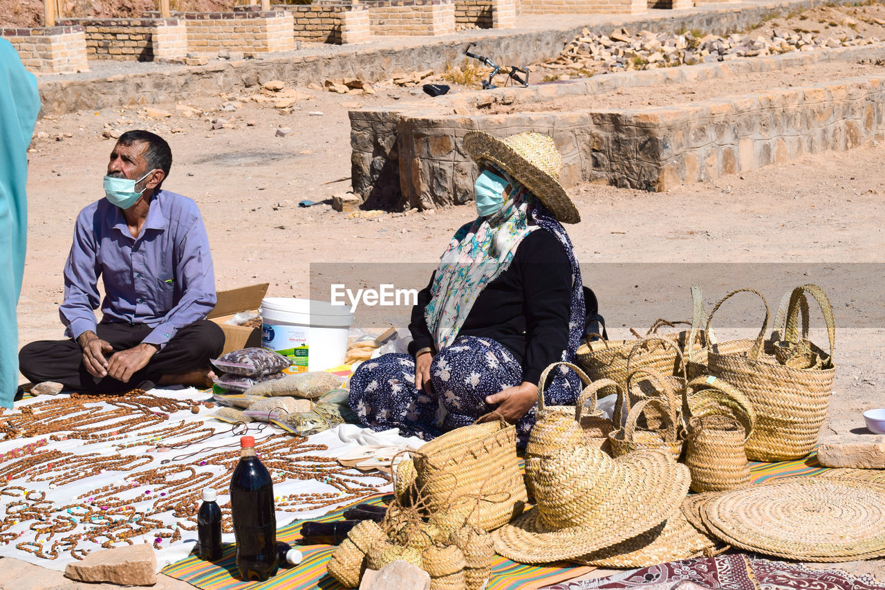 Rear view of a man and a woman selling mat-weaver handicrafts