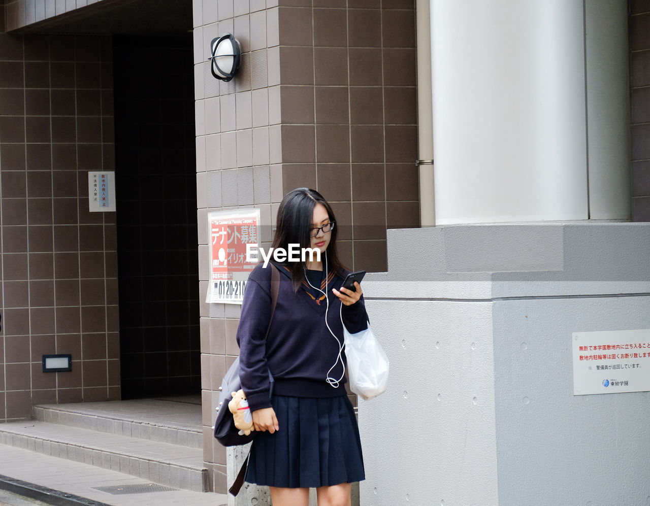 Young woman using mobile phone in city