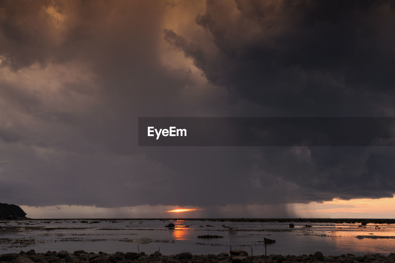 SCENIC VIEW OF BEACH AGAINST SKY AT SUNSET