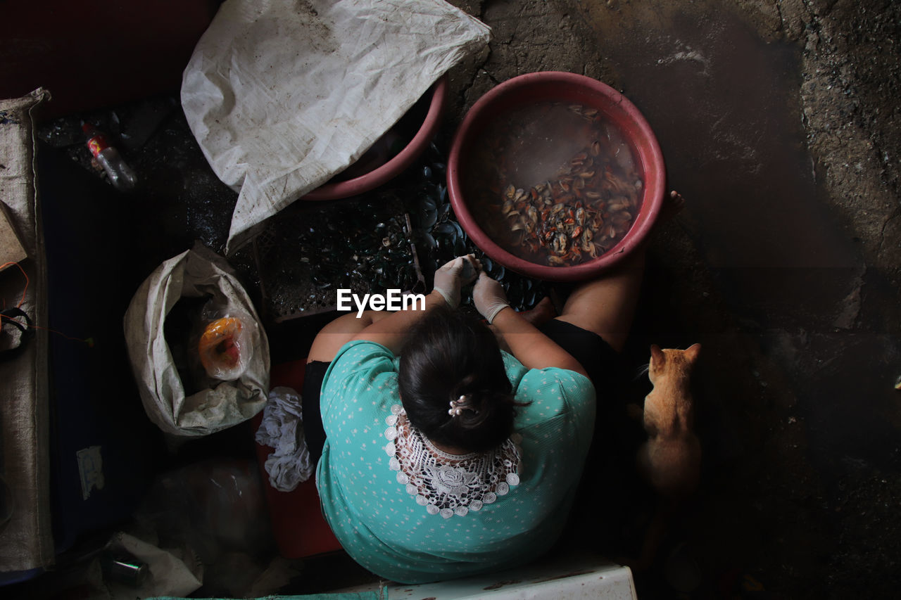 HIGH ANGLE VIEW OF WOMAN HOLDING COOKING IN PAN