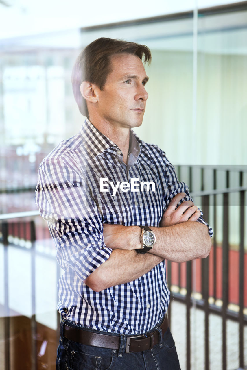 Handsome mature man standing with arms crossed