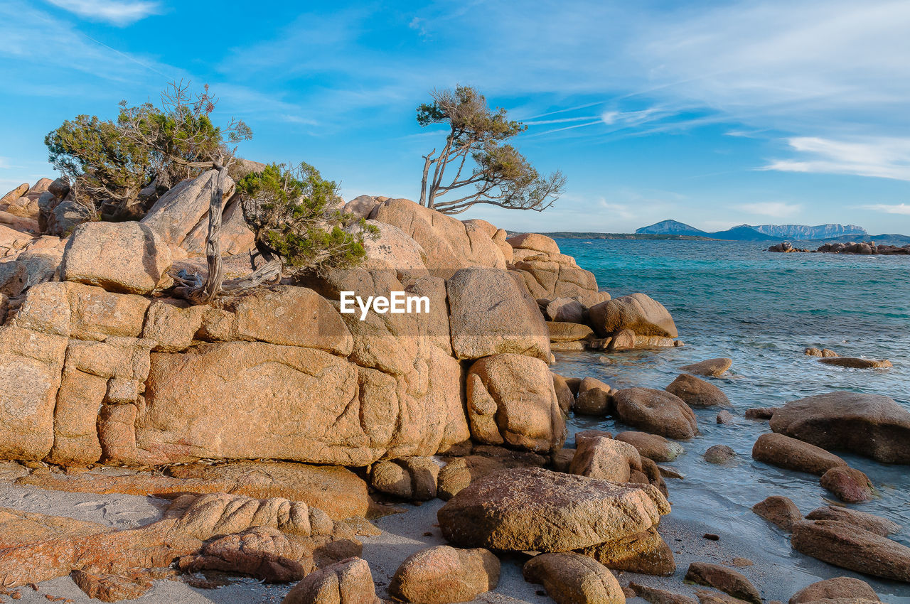 Rock formation on beach against sky