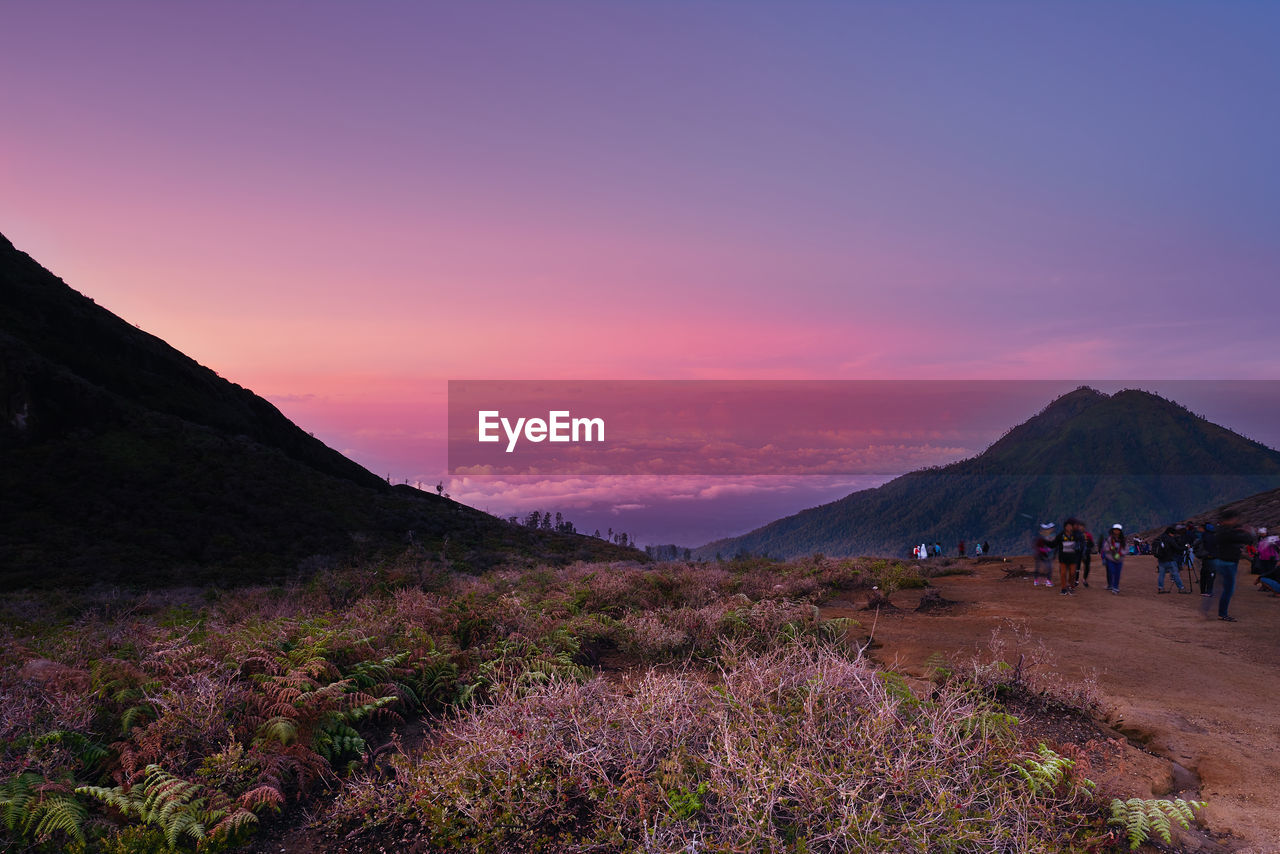 PEOPLE WALKING ON MOUNTAIN AGAINST SKY