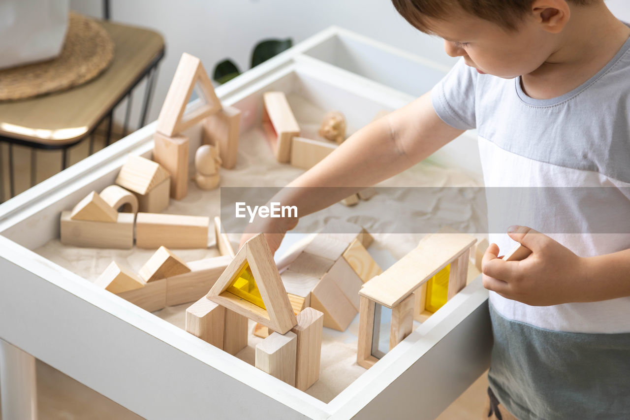 side view of man playing with toy blocks