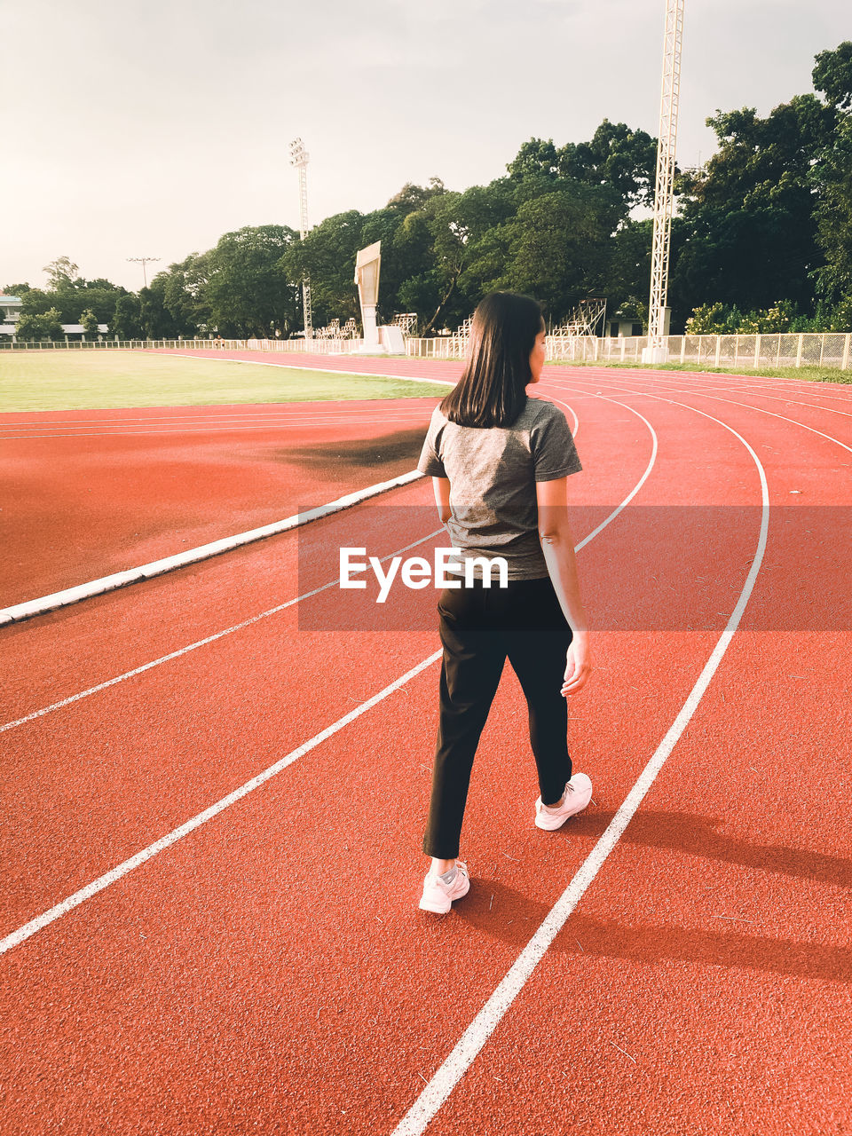 Full length rear view of woman walking on field