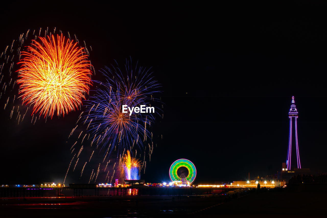 Low angle view of firework display at night