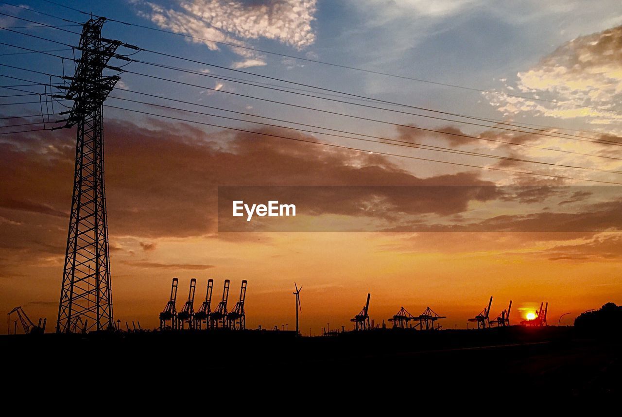 SILHOUETTE ELECTRICITY PYLONS AGAINST SKY DURING SUNSET