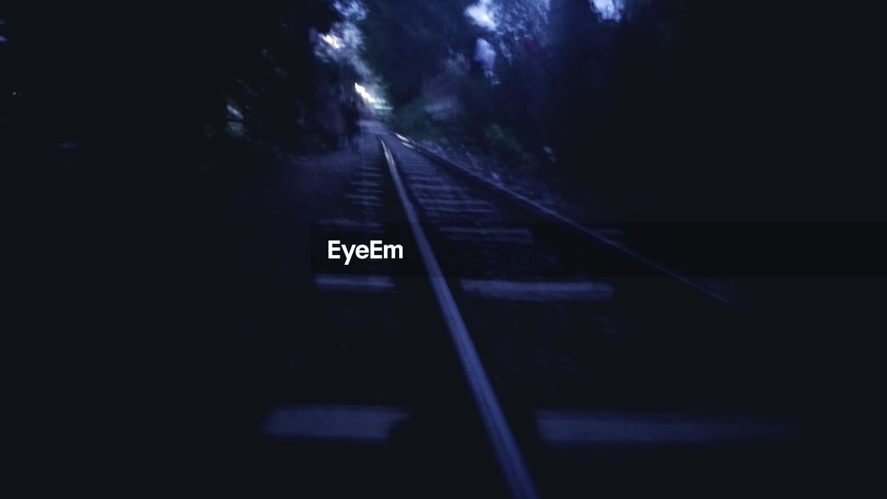 LOW ANGLE VIEW OF RAILWAY TRACKS AT NIGHT