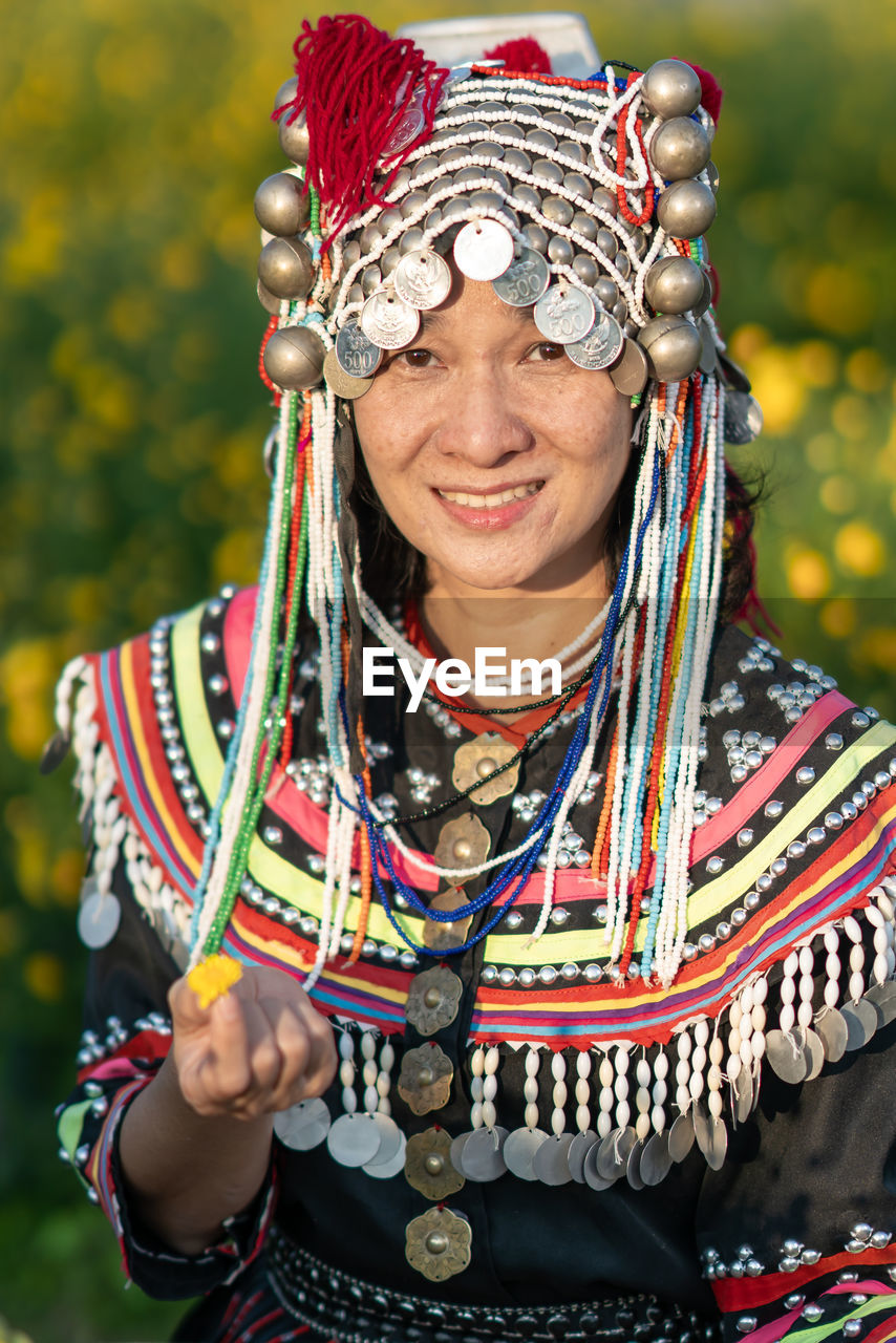 Portrait of smiling woman in traditional clothing standing at farm