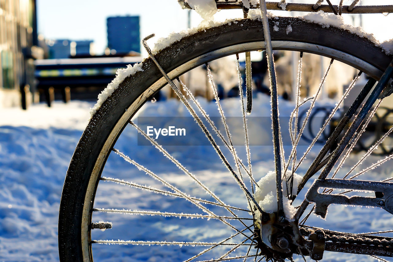 Close-up of snow on bicycle at street