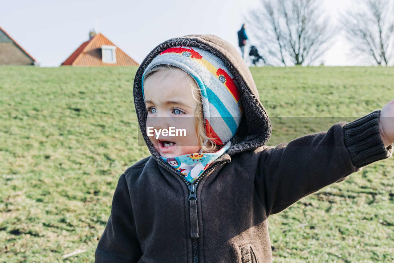 PORTRAIT OF CUTE BOY LOOKING AWAY ON FIELD