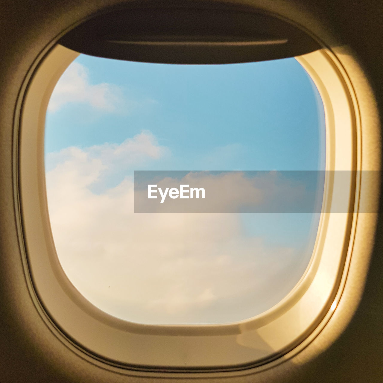 Cloudy sky seen through airplane window