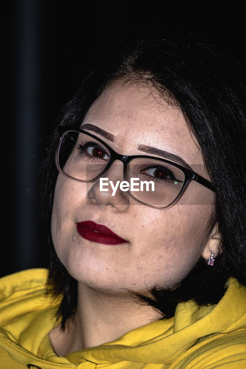 Close-up portrait of young woman wearing eyeglasses