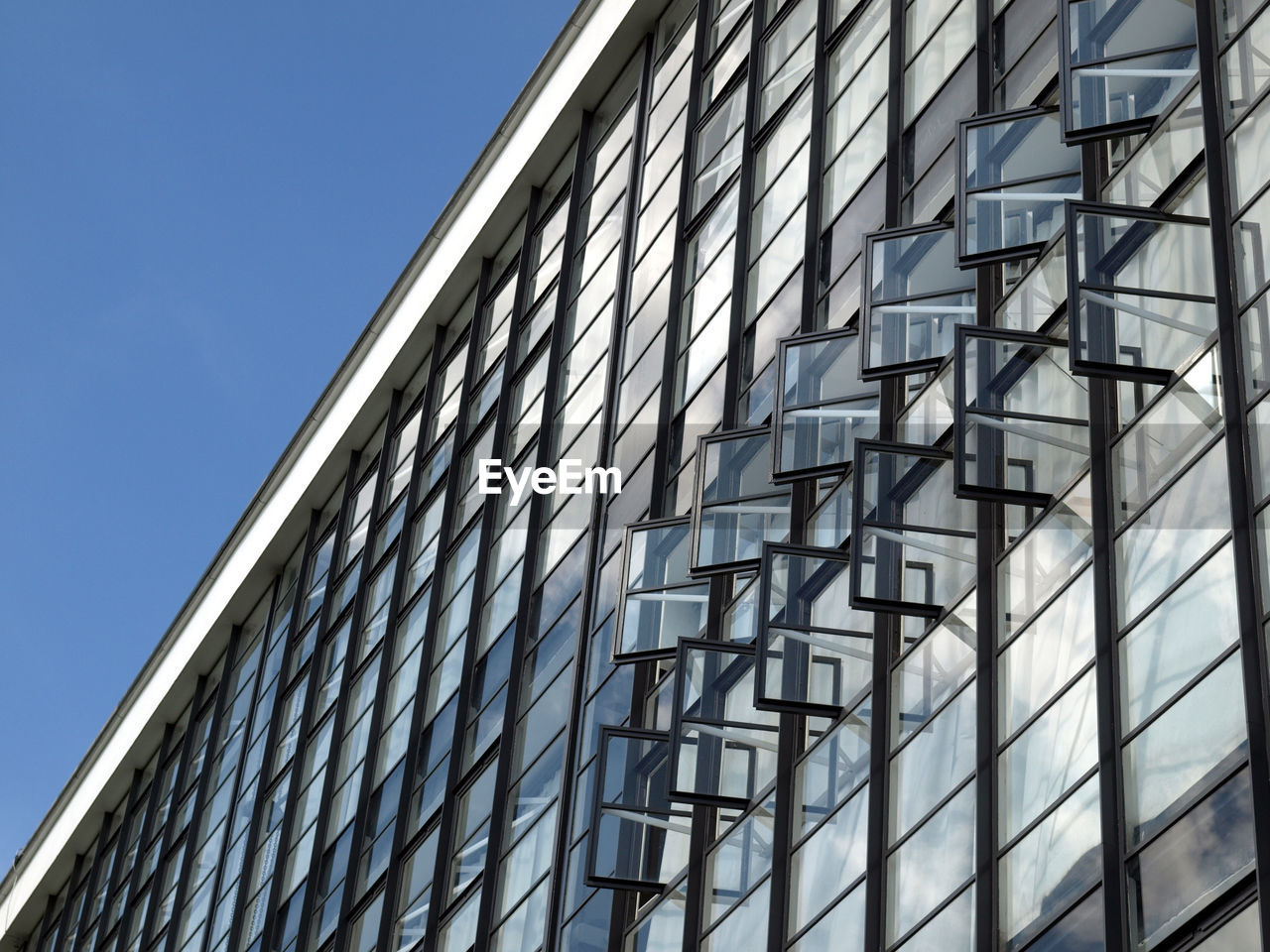 Low angle view of modern building against clear blue sky