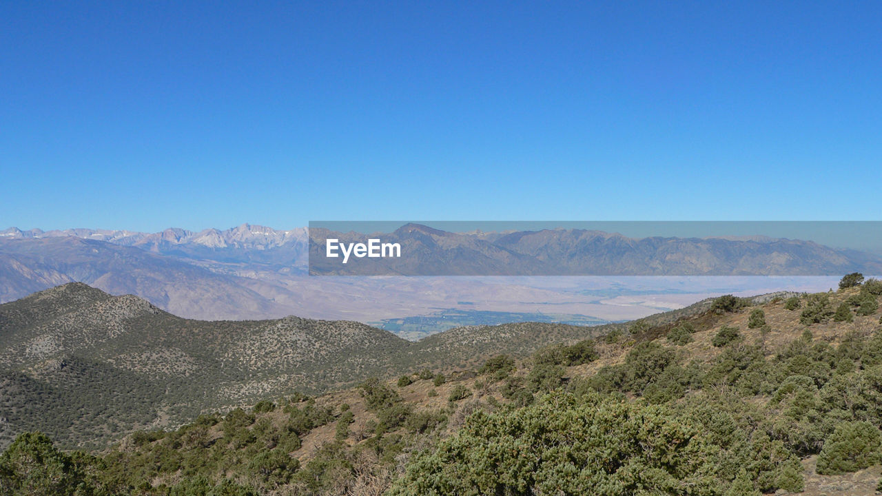 Scenic view of mountains against clear blue sky