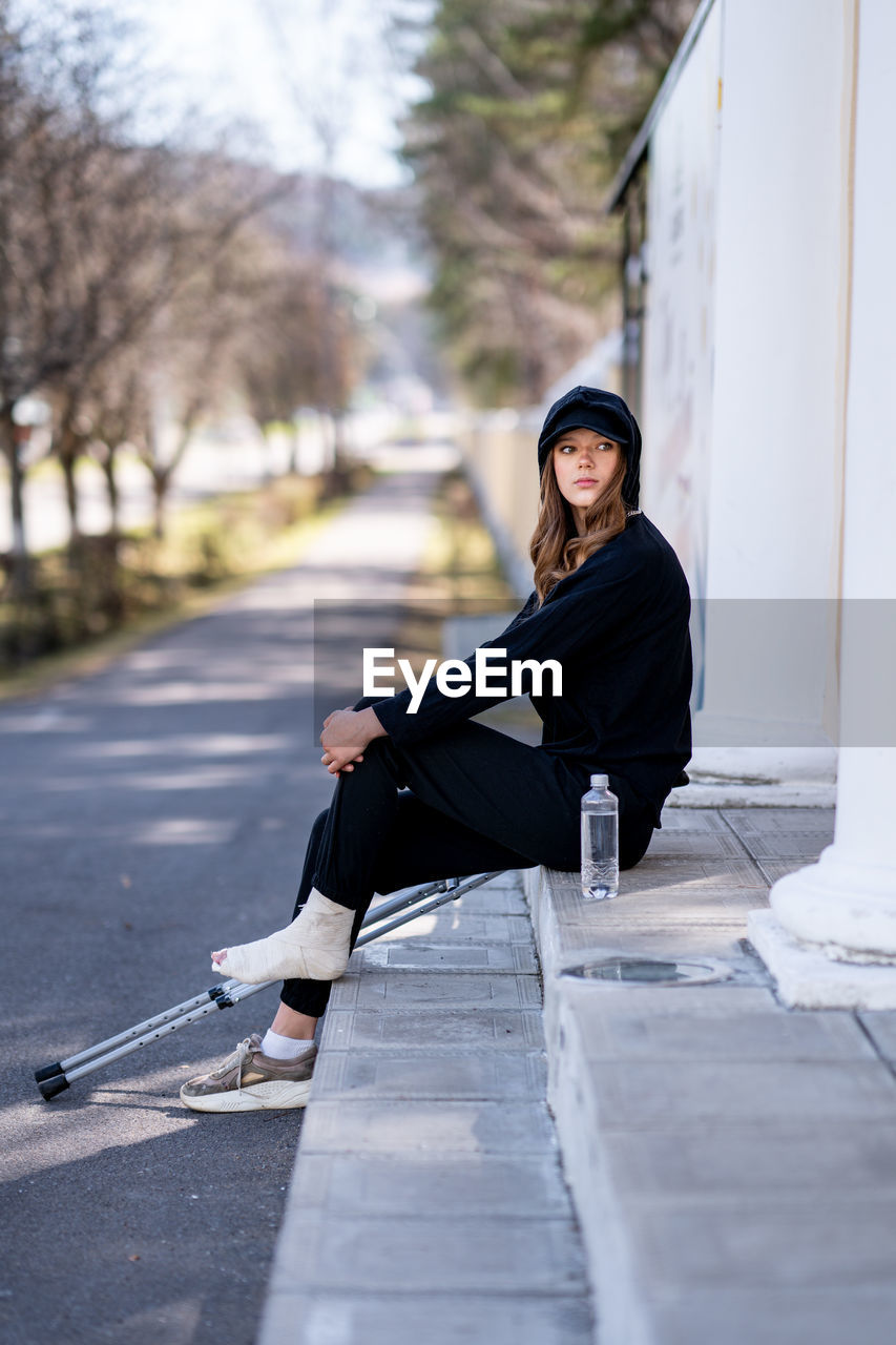 portrait of young woman walking on footpath