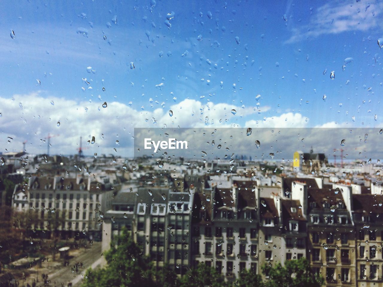 BUILDINGS SEEN THROUGH WET GLASS WINDOW