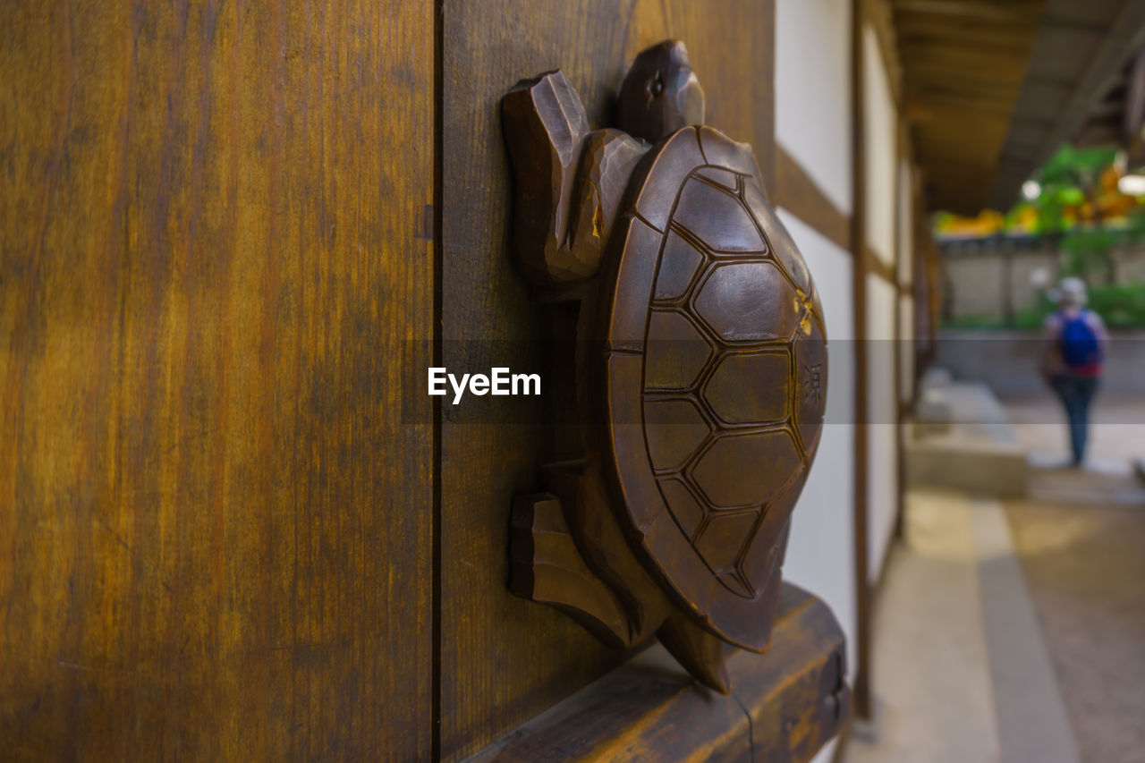 Close-up of wood crafting on wall against building