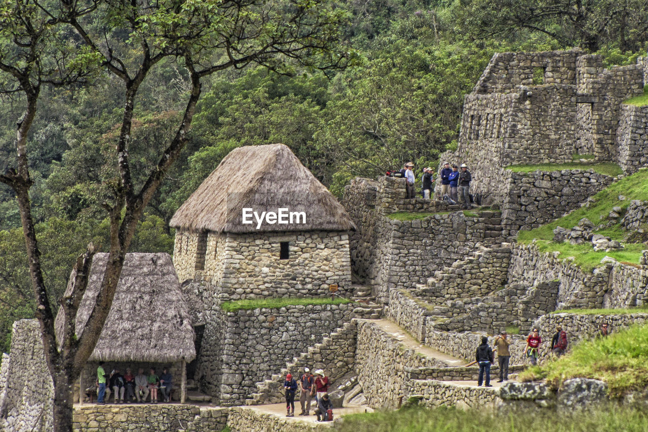 PEOPLE OUTSIDE TEMPLE IN TRADITIONAL BUILDING