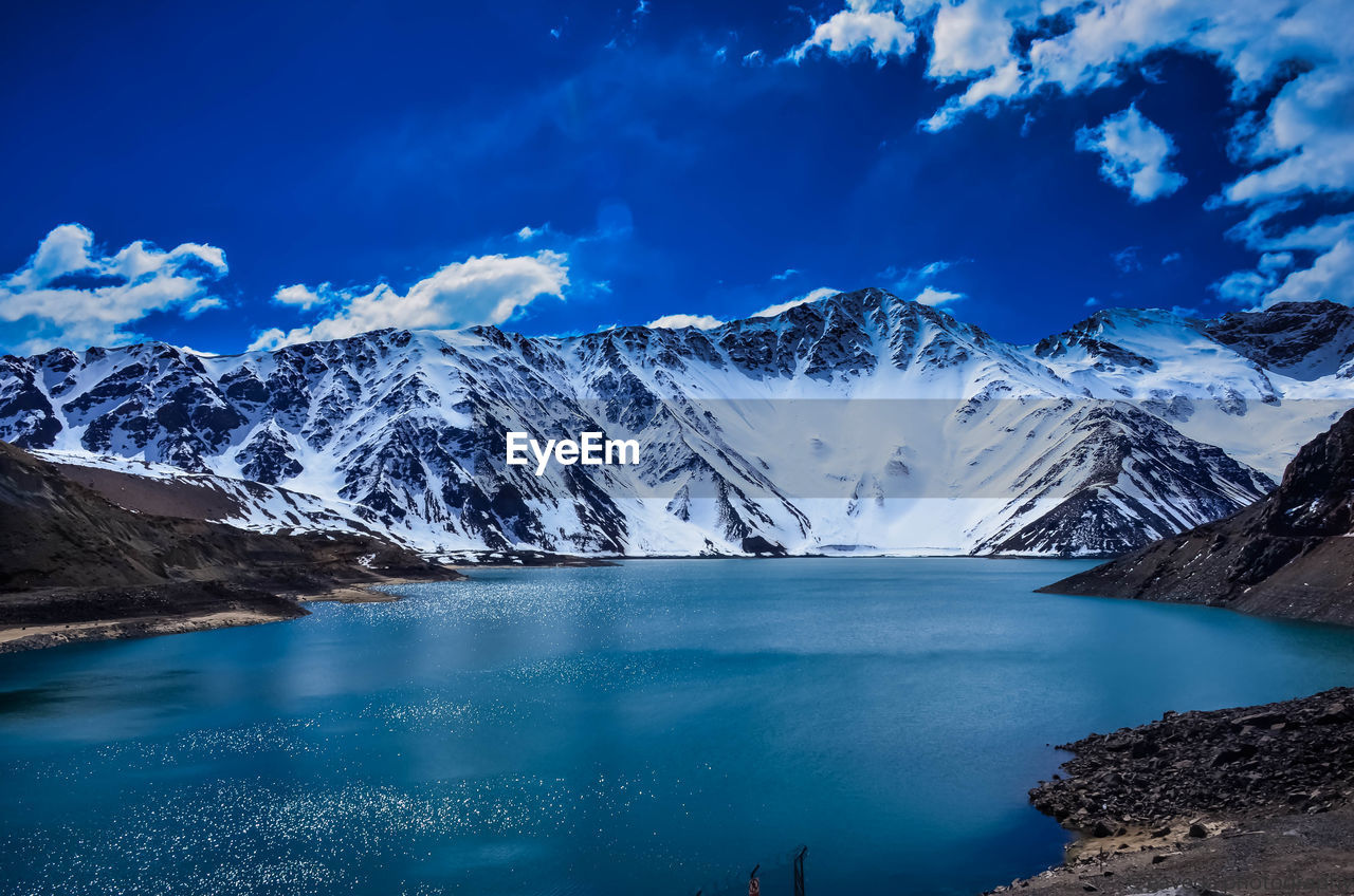 Scenic view of snowcapped mountains against blue sky