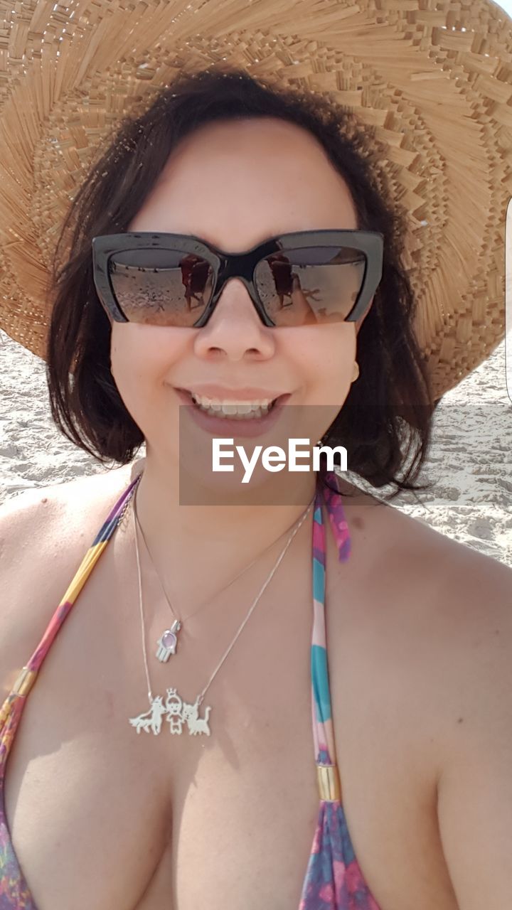Sensuous woman wearing hat at beach
