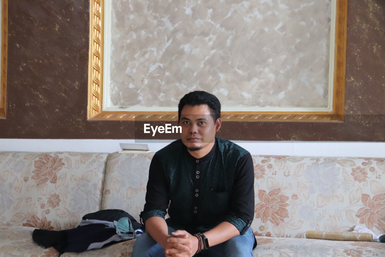 Portrait of young man sitting at home