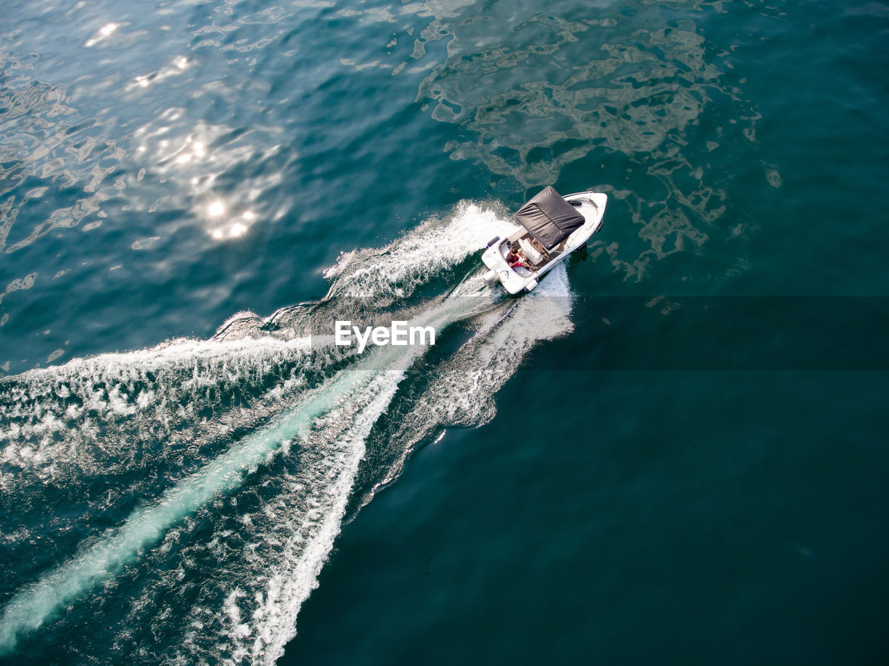 HIGH ANGLE VIEW OF MAN SAILING ON SEA